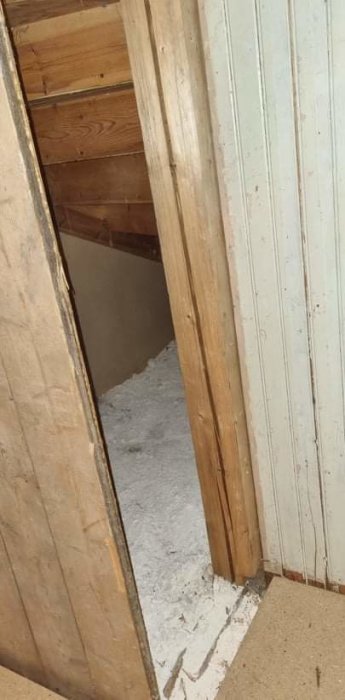 Vitt, klumpigt pulver liknande kattsand på betongplatta bakom öppen vägg under renovering.