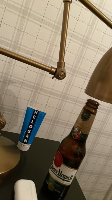 Ölflaska bredvid tandkrämstube och tandborstfodral på badrumsbänk.