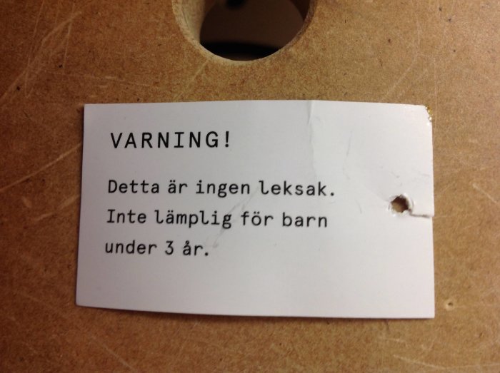 Varningsetikett på verktyg med texten "Detta är ingen leksak. Inte lämplig för barn under 3 år.