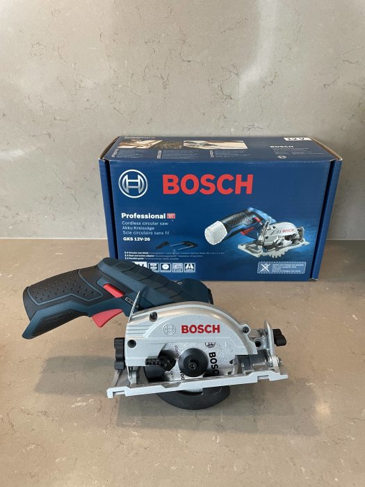 Bosch professionell sladdlös cirkelsåg framför sin förpackning på en betongyta.