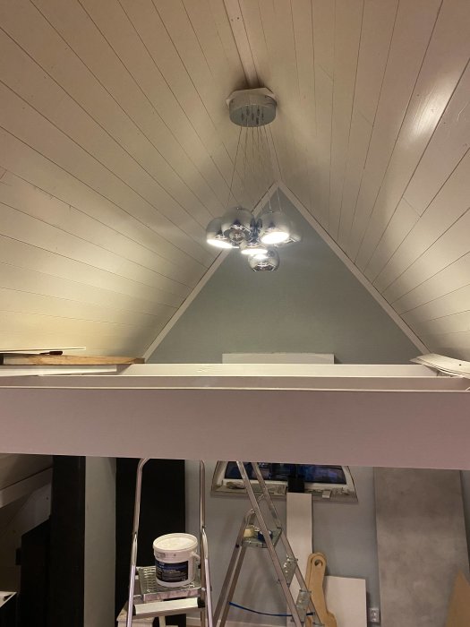 Renoverad vind med nytt tak, ledspotlights och en stege under arbete.