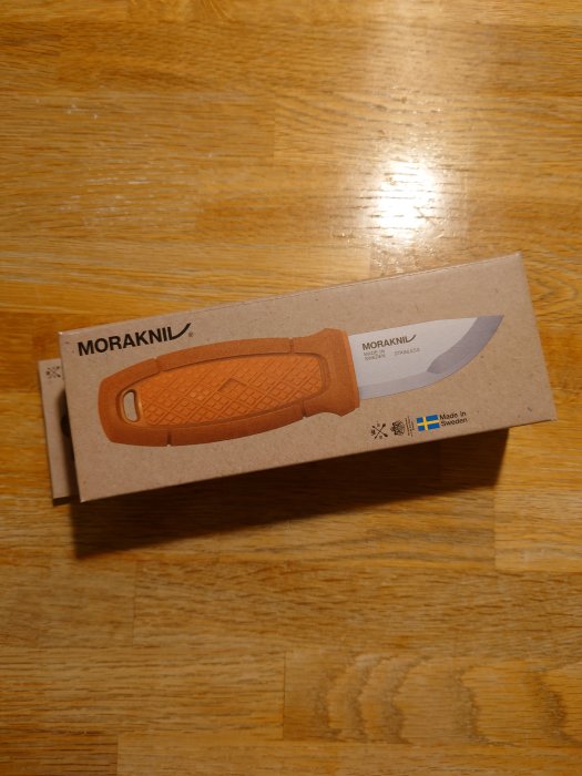 Morakniv i förpackning på träbord, märkt "Made in Sweden".