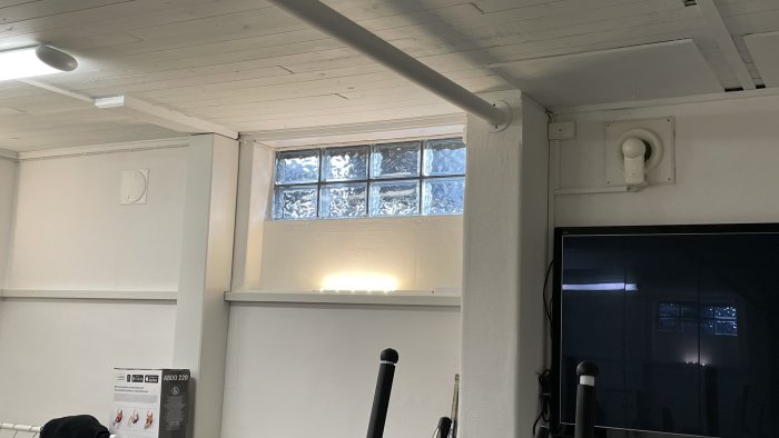 Nyinstallerat FTX-ventilationssystem och vitmålade rör längs taket i ett källarrum.