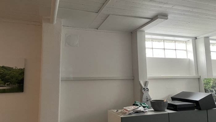 Inomhusvy som visar nyligen installerad FTX-ventilationsanordning på en vitmålad vägg med fönster.