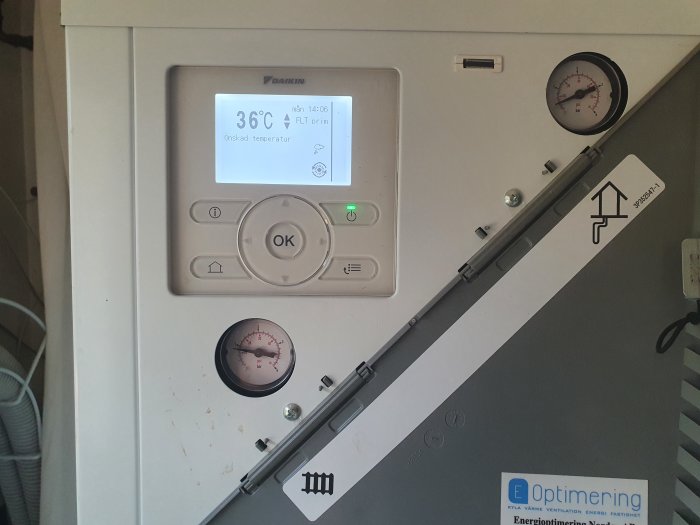 Daikin bergvärmepumpens kontrollpanel visar 36°C, omgiven av manometrar och en datalogger.