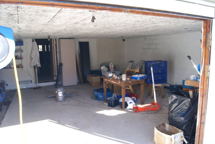 Garage med målarförnödenheter och verktyg, före renovering och organisering.