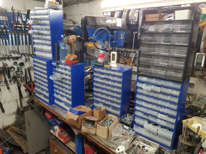 Arbetsbänk och verktygshyllor med sortimentlådor i ett organiserat och användt garage.