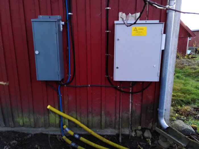 Nyinstallerat Hager Gamma elskåp på röd vägg med ledningar och blå nätverksslang som går åt olika håll.
