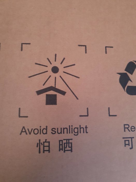 Symbol för sol med texten "Avoid sunlight" på en kartong som indikerar att innehållet är känsligt för ljus.