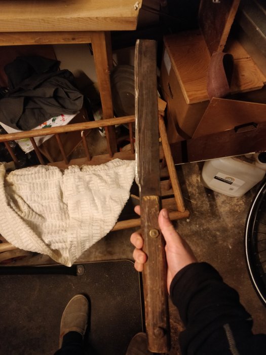 Person håller en lång, grov kniv i verkstaden, potentiell froe modifikation.