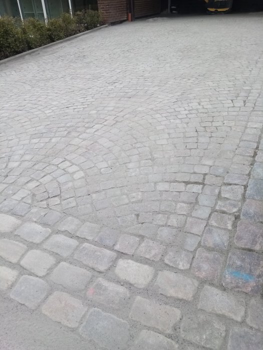 Gatsten av granit från svenskt urberg, handhuggen till kullersten på 1800-talet, använd som beläggning.