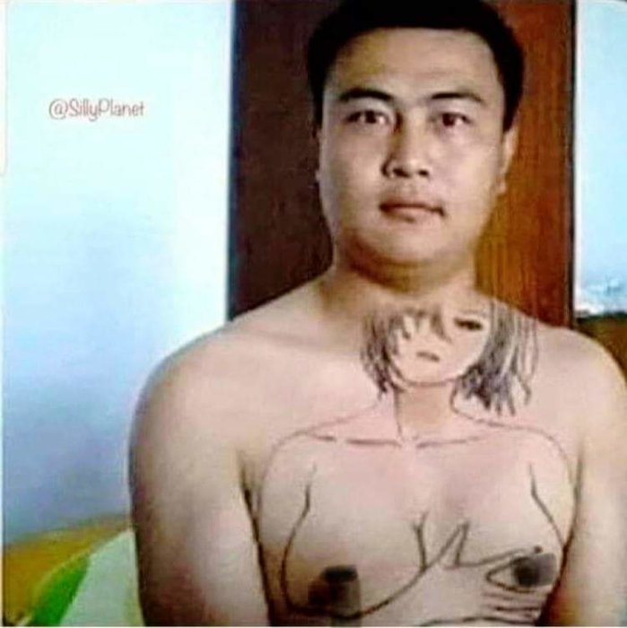 Man med teckning av kvinnokropp på sin egen torso ser i kameran.