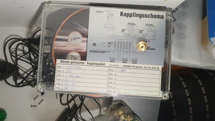 Kopplingsschema för golvvärme med beteckningar och handskrivna noteringar på en kopplingssplint.