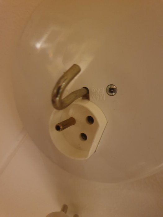 Närbild på ett vitt takuttag med en löst hängande kopplingsdel, vilket indikerar en inpassningsproblem.