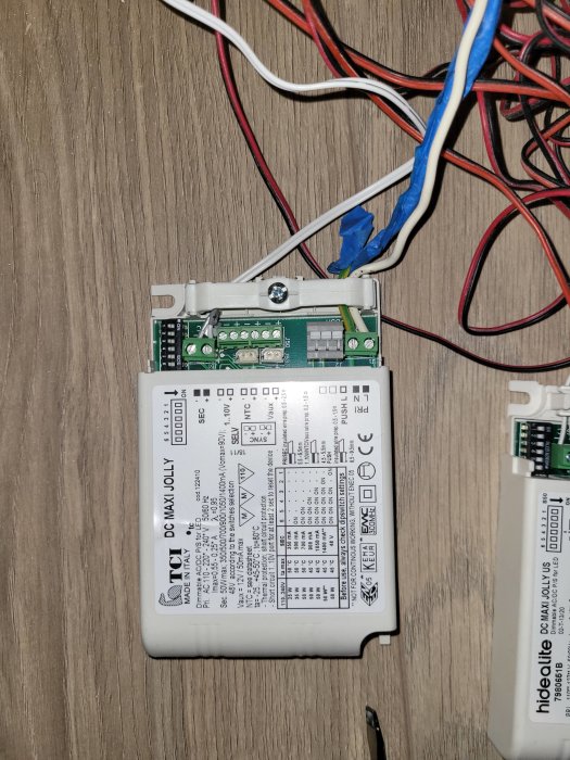 Transformer i en virrvarr av kablar på ett golv, möjligtvis orsak till svagt ljus i köksspottar.