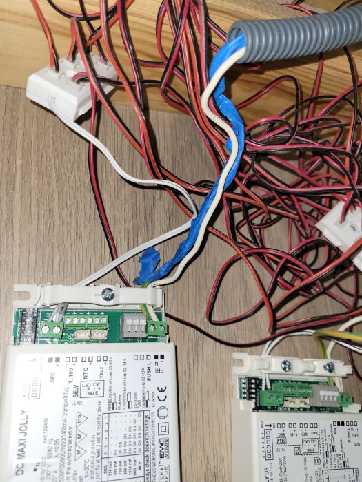 Elektrisk anslutning med två transformatorer och oorganiserade kablar på ett bygge.
