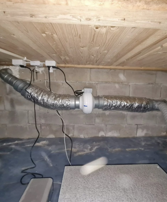 Två ljuddämpare installerade på ventilationsrör i ett oisolerat utrymme.