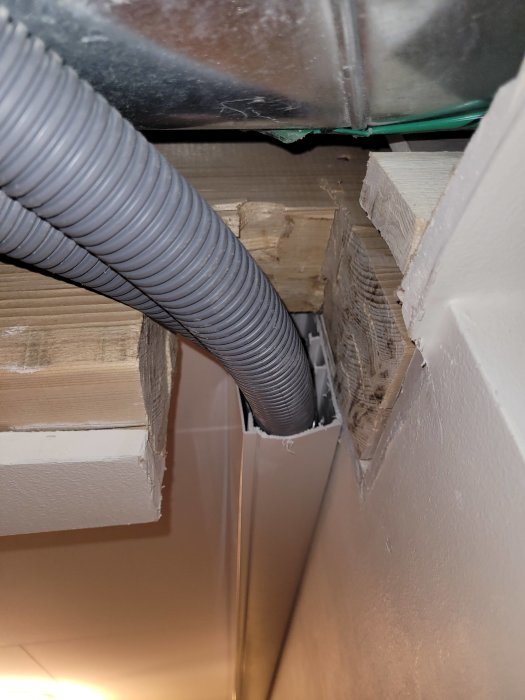 Utsågad del av en bärande balk med golvvärmerör installerade i närheten i ett hem.