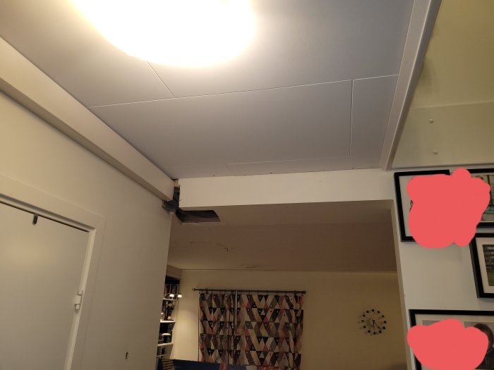 Skada på balk hörn ovanför dörröppning, med synlig skada och exponerad insida.