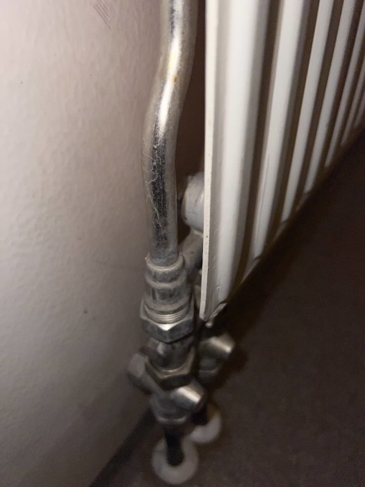 Radiatorkoppling med synligt rör och ventil vid element, fråga om 1- eller 2-rörssystem.