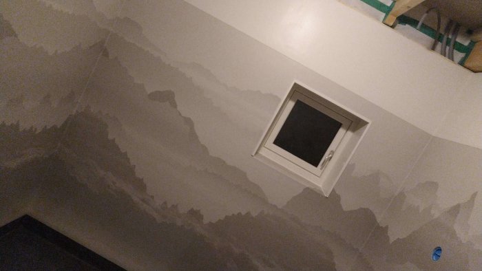 Bergsinspirerad våtrumsmatta med mönster av alptoppar och moln på vägg i badrum.