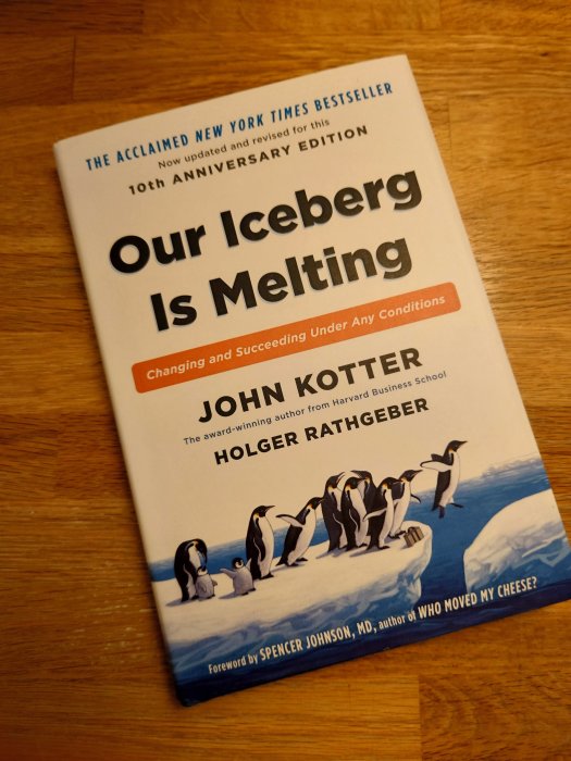 Omslag till boken "Our Iceberg Is Melting" av John Kotter och Holger Rathgeber med pingviner på ett isberg.