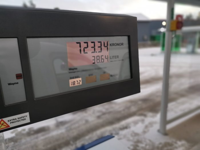 Bensinpumpens display med priset 12.34 kr/liter diesel i ett snöigt landskap.