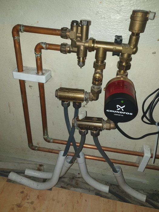 Kopparledningar och värmeinstallation med en ny Grundfos pump, termostat och ventiler.