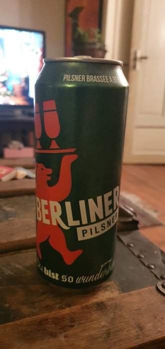 Ölburk med Berliner Pilsner-logotyp på ett mörkt träbord, omtalad som "ny bekantskap" i inlägget.