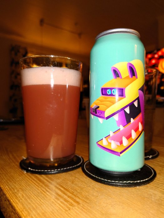 Ett glas med nyponsoppa och en färgglad burk med tecknad figur på en träyta.