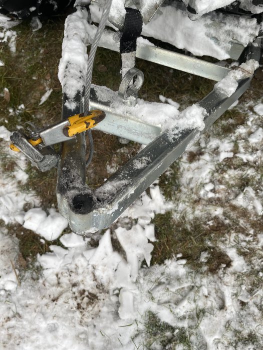 Demontage av plogfäste med synligt 20 mm hål på en snöig mark.