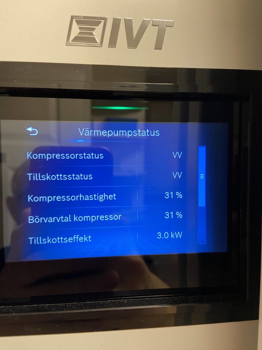 Display på en värmepumps kontrollpanel som visar aktuell status och siffror för kompressor och tillskottseffekt.