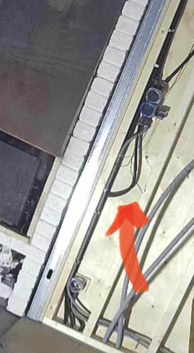 Installation av elinstallationer i en byggnadskonstruktion med exponerade kablar och isolerkanaler.