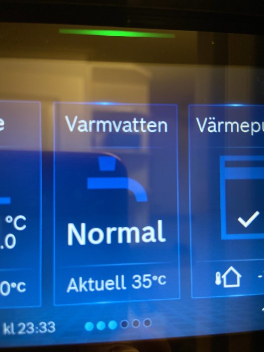 Digital display på en värmepump med texten "Varmvatten Normal Aktuell 35°C", indikerar att vattnet har uppnått önskad temperatur.