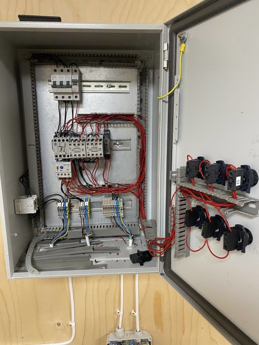 Elektriskt skåp under installation med Y/D-koppling, säkringar, kablar och kontaktorer.