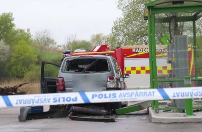 Skadad bil efter explosion vid biogasstation med räddningstjänst och polisavspärrning i bakgrunden.