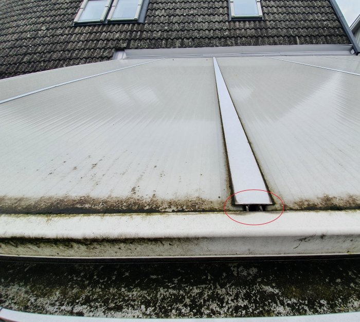 Glipa vid skarvlisten på ett uterumstak markerad med röd cirkel, möjlig läckagepunkt.