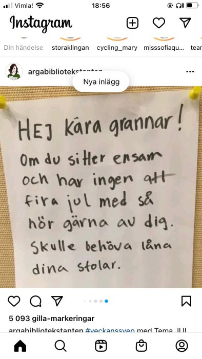 Handskriven lapp upphängd på en anslagstavla med texten "HEJ kära grannar! Om du sitter ensam och har ingen att fira jul med så hör gärna av dig. Skulle behöva låna dina stolar.