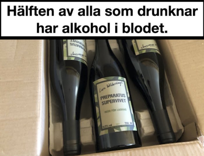 Vinflaskor i låda med texten "Hälften av alla som drunknar har alkohol i blodet".