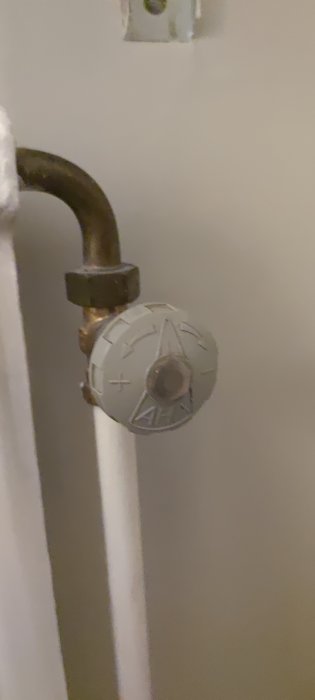 Radiator termostat med halvöppen ventil och korroderade rör.