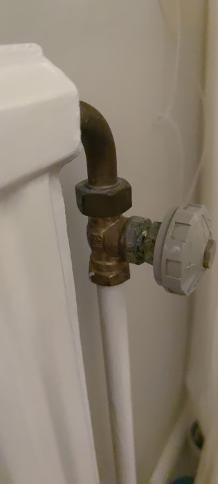 Termostat på radiator med synligt rör, problem med uppvärmning beskrivs i inlägg.