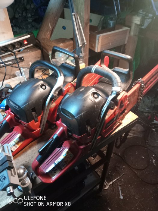 Två Jonsered motorsågar på en arbetsbänk med verktyg, i förberedelse för gallringsjobb.