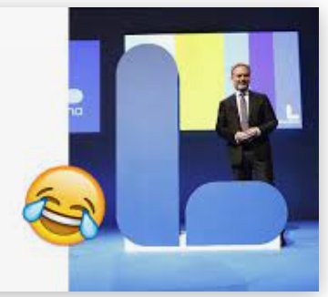 Person står leende framför en logotyp som kan tolkas som någonting olämpligt.