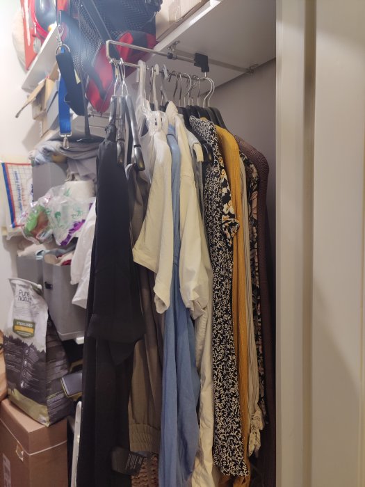 Rörigt walk-in-closet med 30cm Elfa hyllsystem och kläder på galgar.