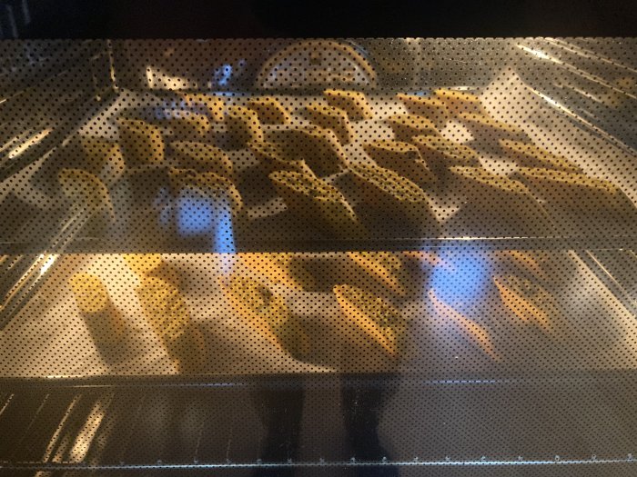 Kakor bakas i en ugn sedda genom en ugnslucka med små prickar.