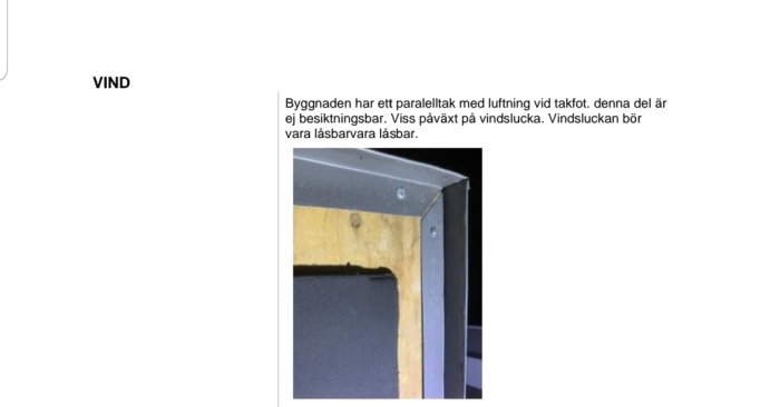 Närbild av en öppen vindslucka med metallram och synlig isolering.