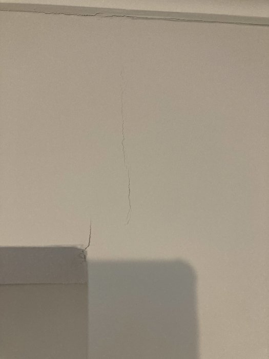 Nymålad vägg med en tydlig spricka sträckande sig från taket neråt.