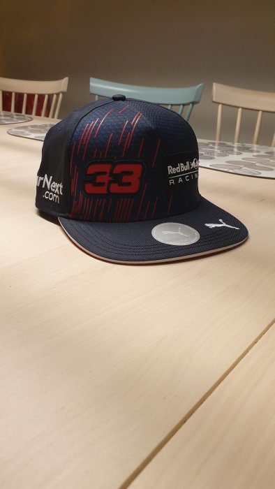 Keps med tryck liggande på bord, Red Bull Racing, nummer 33, Puma-logotyp.