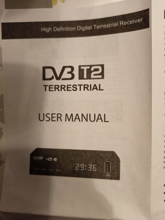 Användarmanual för en digital mottagare DVB T2 med enheten synlig.