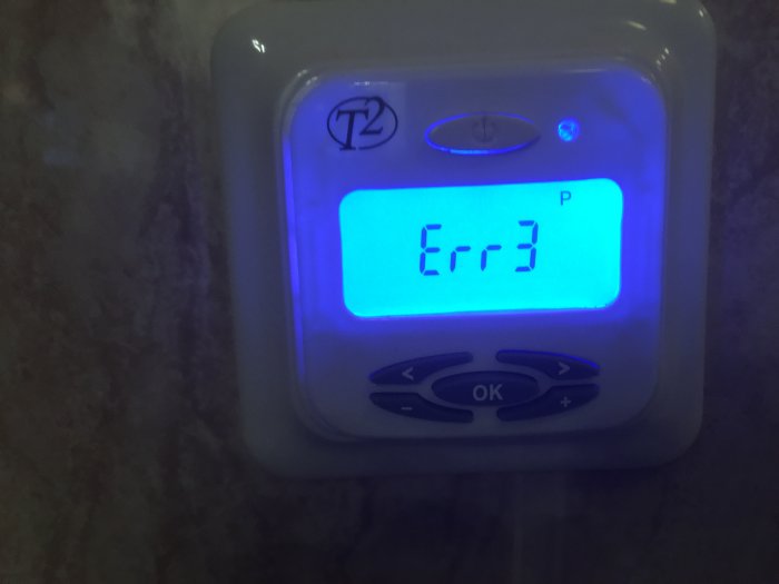 Golvvärmetermostat som visar felkod 'Err3' på en upplyst display.